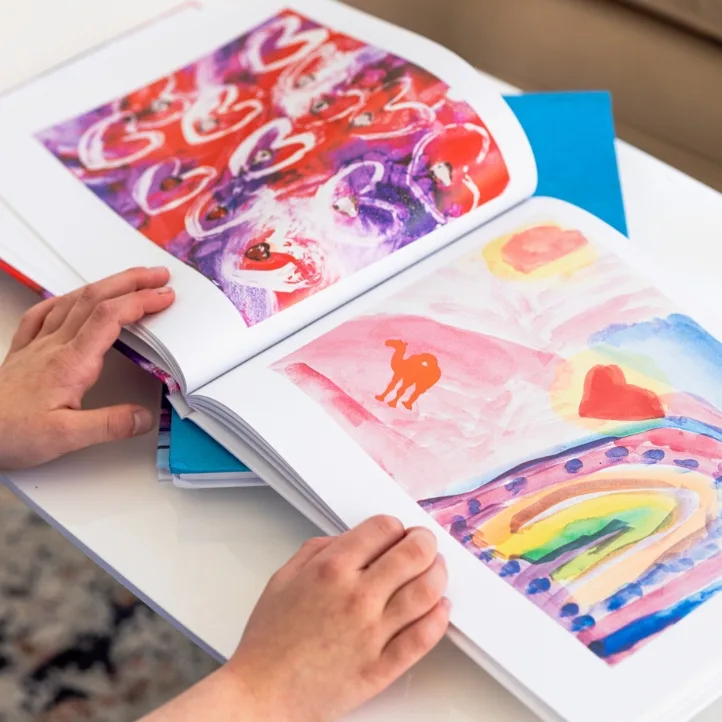 Close-up of hands turning pages of a finished Artkive book