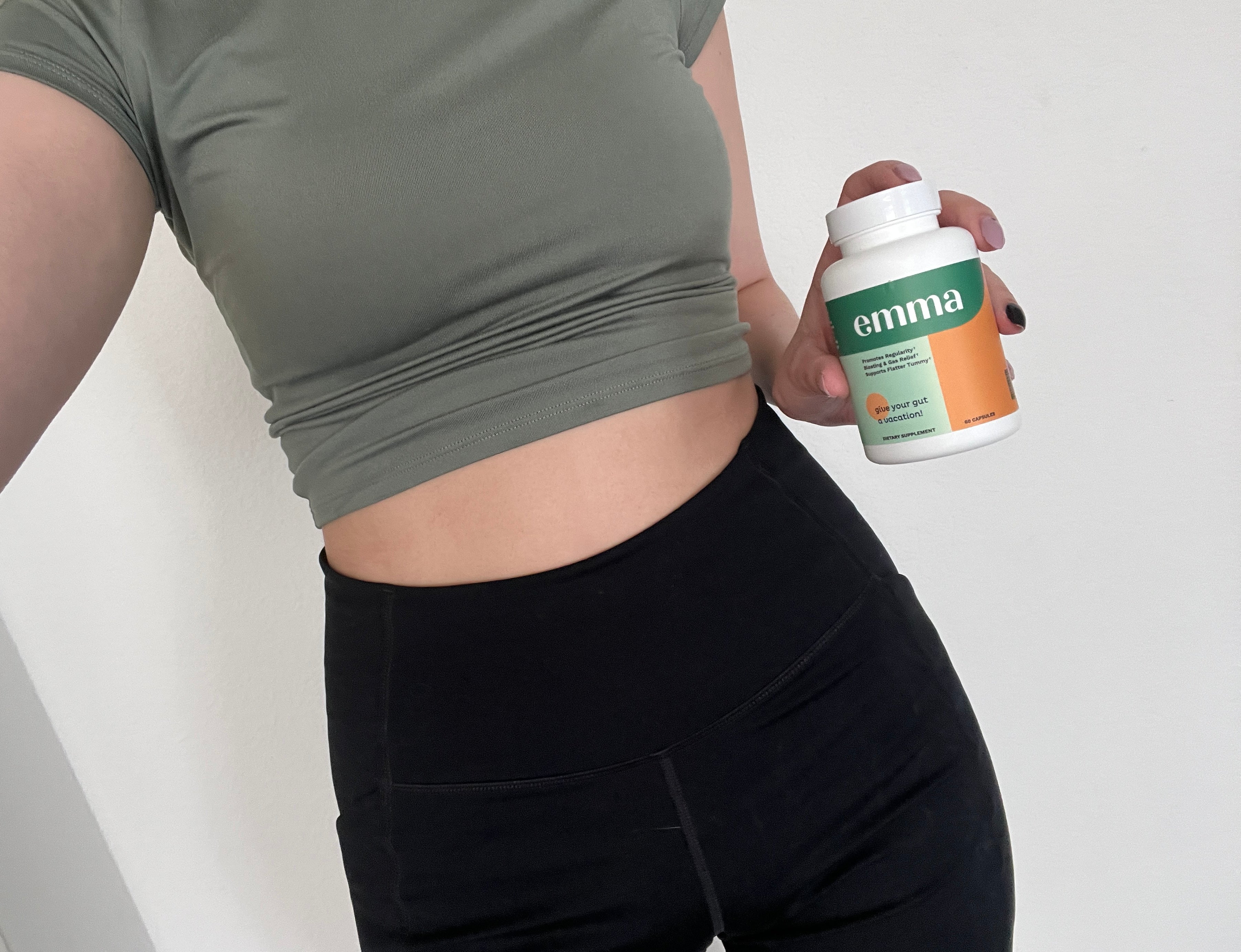 Person holding Emma supplement bottle in front of their torso