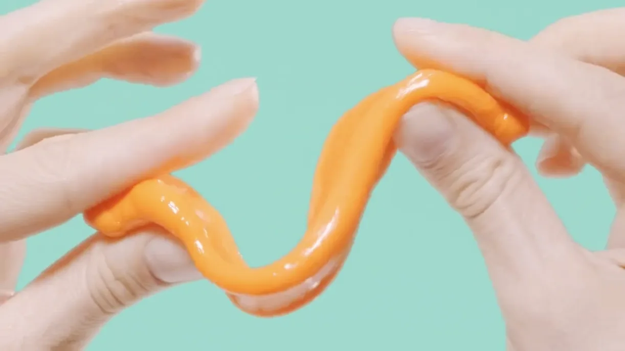 Close-up of hands stretching a softened orange FixIts stick