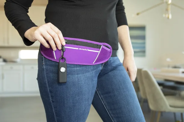 A purple Hootie alarm clipped to a fanny pack