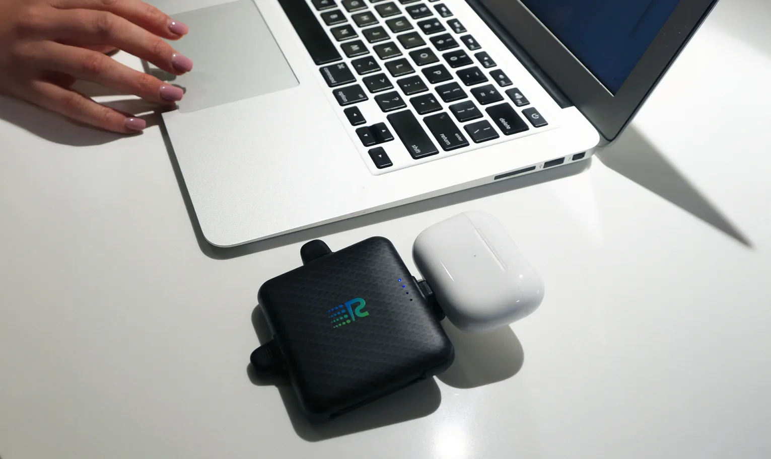 Rush Charge Universe on a desk with a laptop and wireless earbuds case