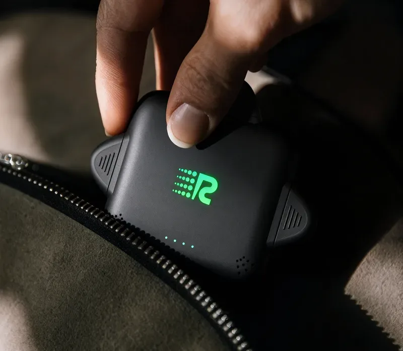 Hand placing Rush Charge Universe charger into a bag, showing portability