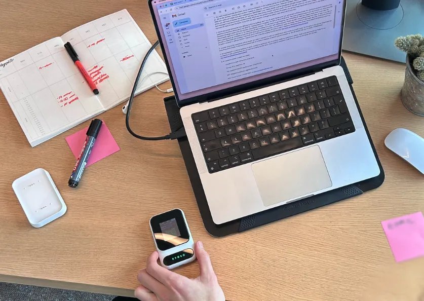 Person using the Ryoko Pro device at a desk with a laptop and office supplies