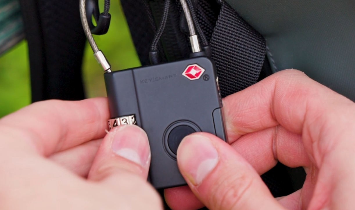 Hands operating SmartLock on a bag strap