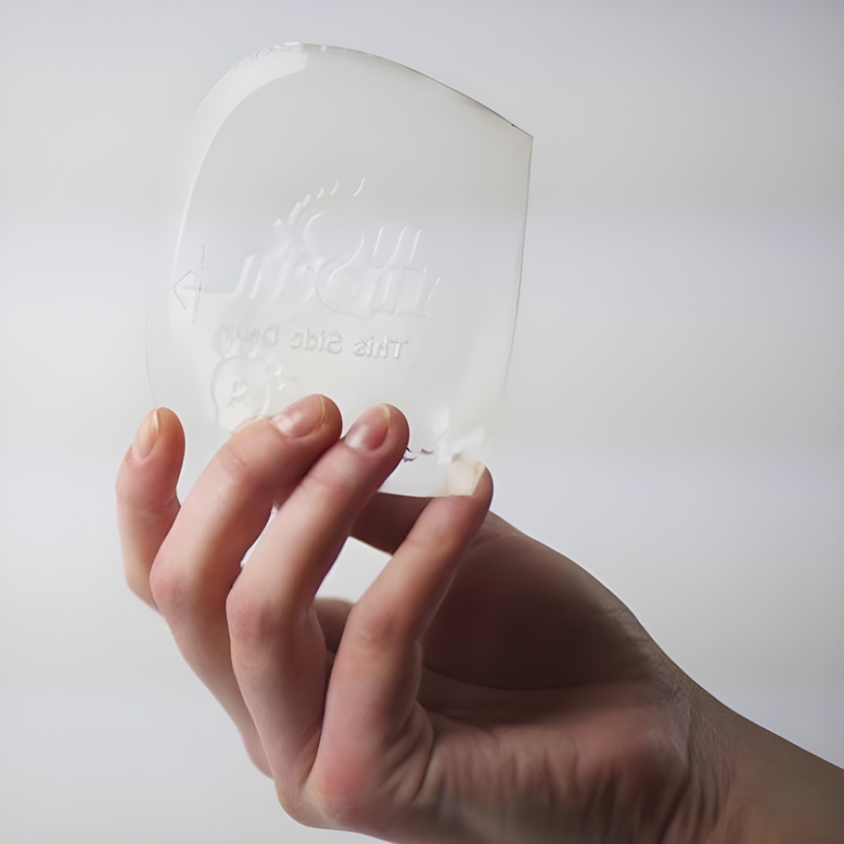 Hand holding a flexible transparent gel insole