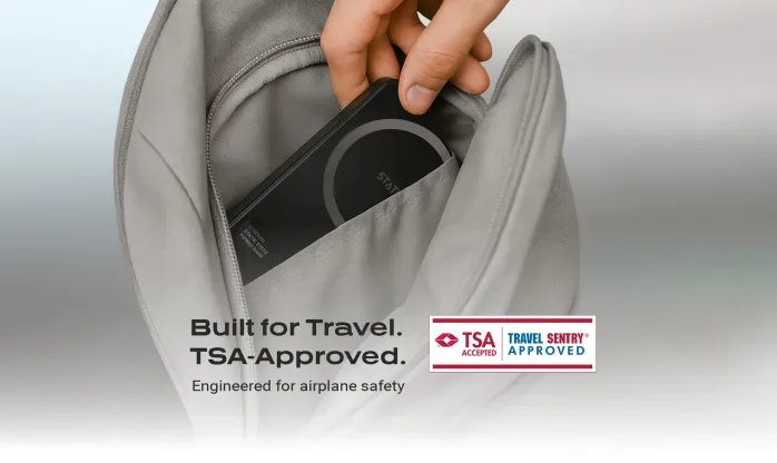 Person placing Statik State power bank into the front pocket of a backpack