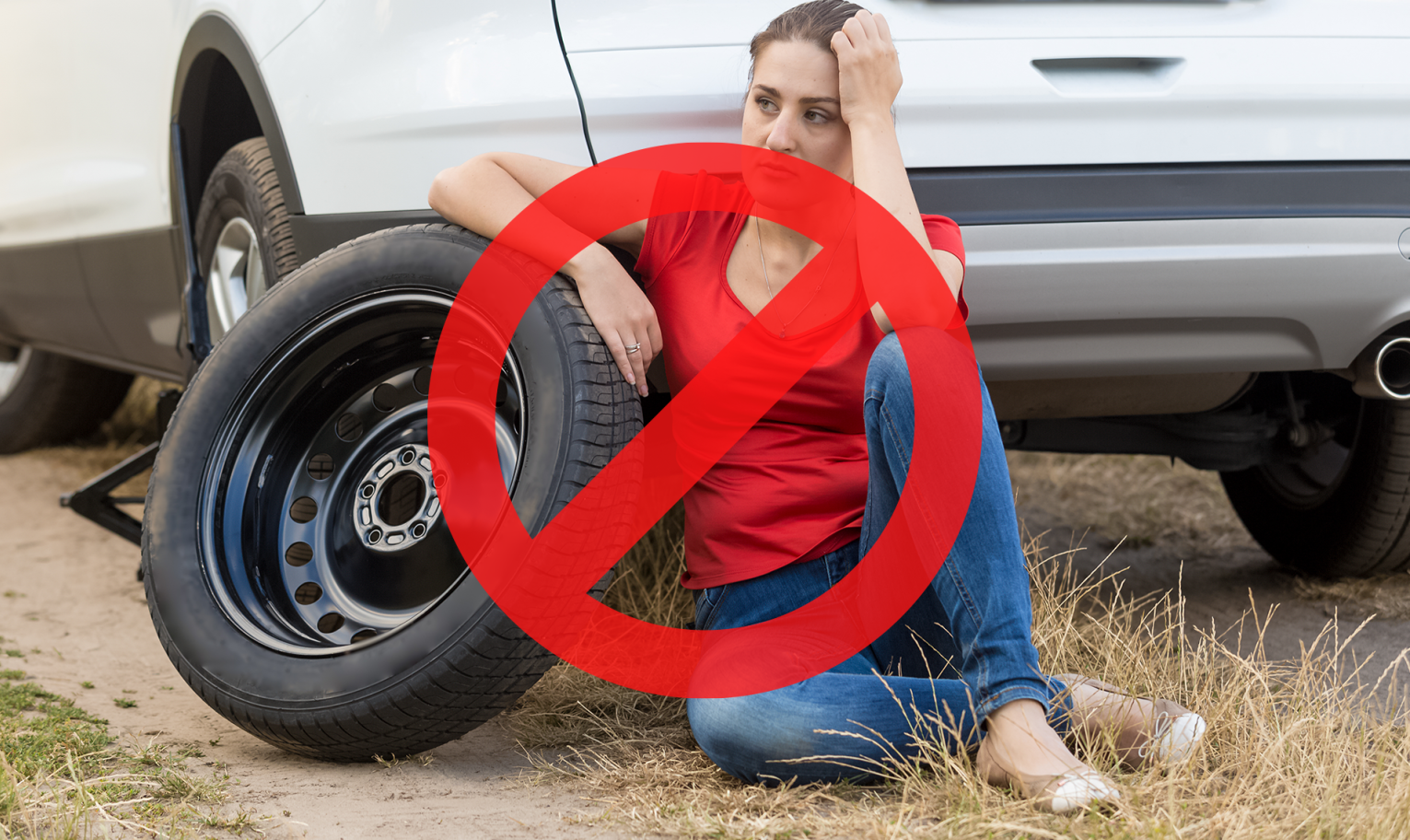 Woman stranded roadside with a flat tire and a red prohibition symbol